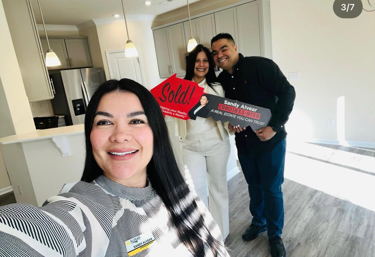 Sandy Alvear selfie with happy clients at new construction home